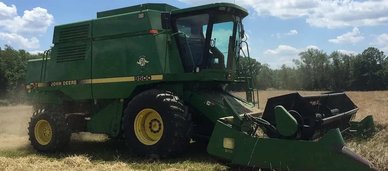 Tidbury Creek Farms & Nursery's Green John Deere 9500 combine harvester in wheat field.