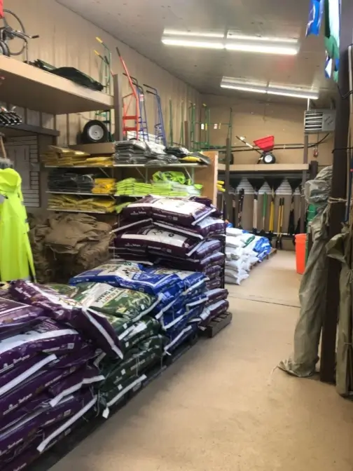 Store aisle with stacked bags and gardening tools